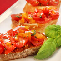Sliced Sweetpops Tomatoes on Slices of Bread with Herbs and Cheese